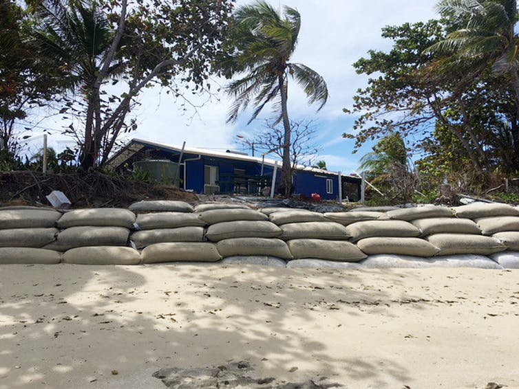 sandbags dividing beach from house